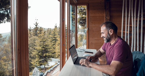 a man sitting at a table with a laptop