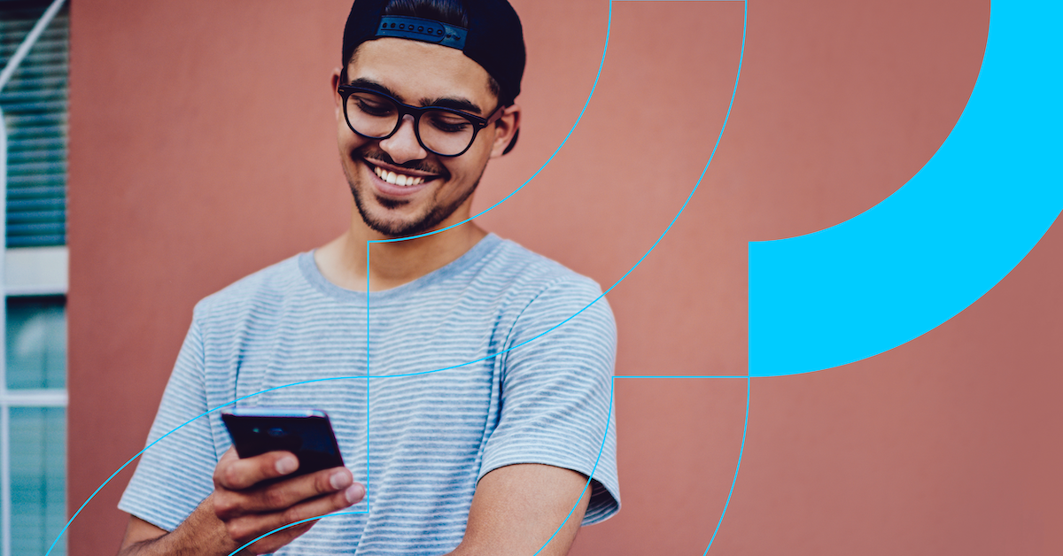 a man wearing a blue shirt and glasses holding a phone